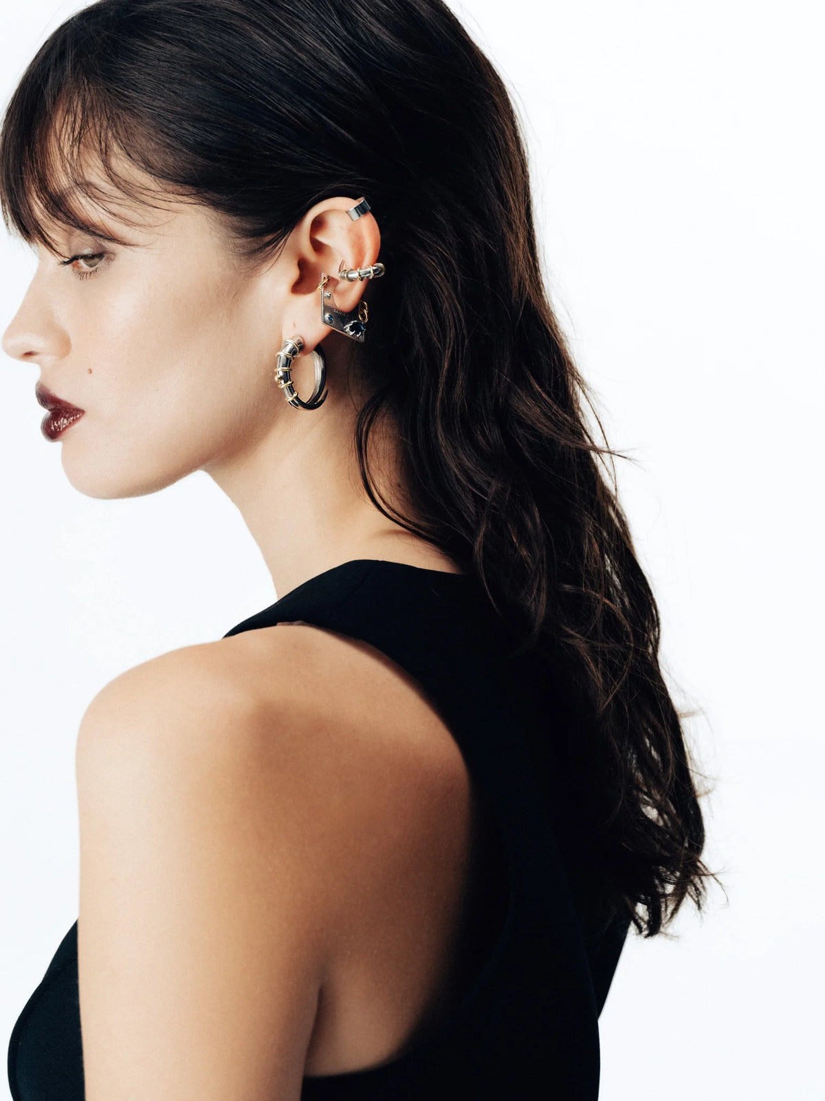 Siyah elbise ile tamamlanan metal earcuff detayı, Jaagravi’nin zarif minimalizm anlayışını modern bir formda sunuyor. Beyaz arka plan, tasarımın gücünü sade bir dengeyle vurguluyor. Pentome Studio’da çekilmiştir.
The metallic earcuff paired with a sleek black dress embodies Jaagravi’s refined minimalism in a contemporary form. The white backdrop enhances the strength of the design through subtle balance. Photographed at Pentome Studio.
