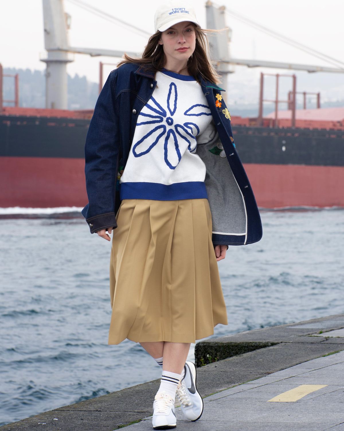 Shopigo markasına ait deniz kenarı çekimi; çiçek işlemeli denim ceket, krem rengi pileli etek ve beyaz sneaker kombinasyonu ile rahat ve zarif bir sokak stili yansıtılmıştır. Pentome Studio’da çekilmiştir.
A seaside fashion shot for the brand Shopigo, featuring a floral embroidered denim jacket, pleated beige skirt, and white sneakers — embodying a relaxed yet refined street style. Photographed at Pentome Studio.