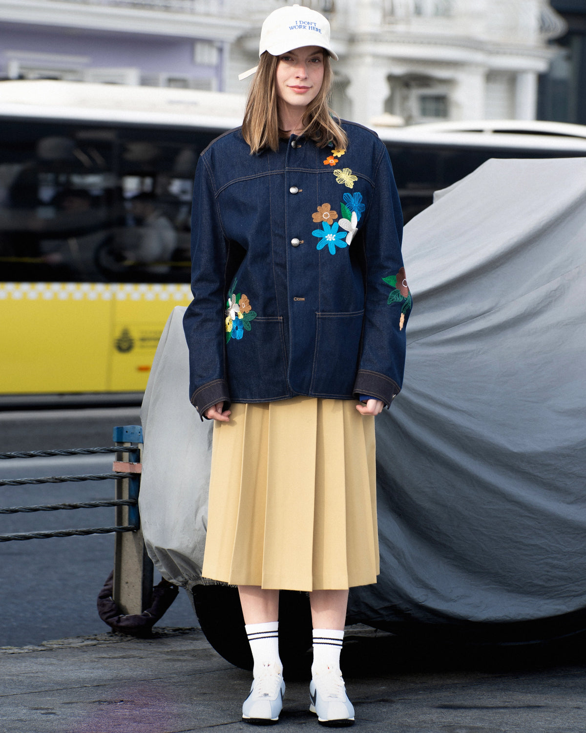 Shopigo markasına ait şehir çekimi; çiçek aplikeli lacivert denim ceket, bej pileli etek ve beyaz sneaker kombinasyonu ile modern şehirli bir tarz sunulmuştur. Pentome Studio’da çekilmiştir.
An urban fashion shot for the brand Shopigo, featuring a navy denim jacket with floral appliqués, pleated beige skirt, and white sneakers — blending street edge with soft elegance. Photographed at Pentome Studio.