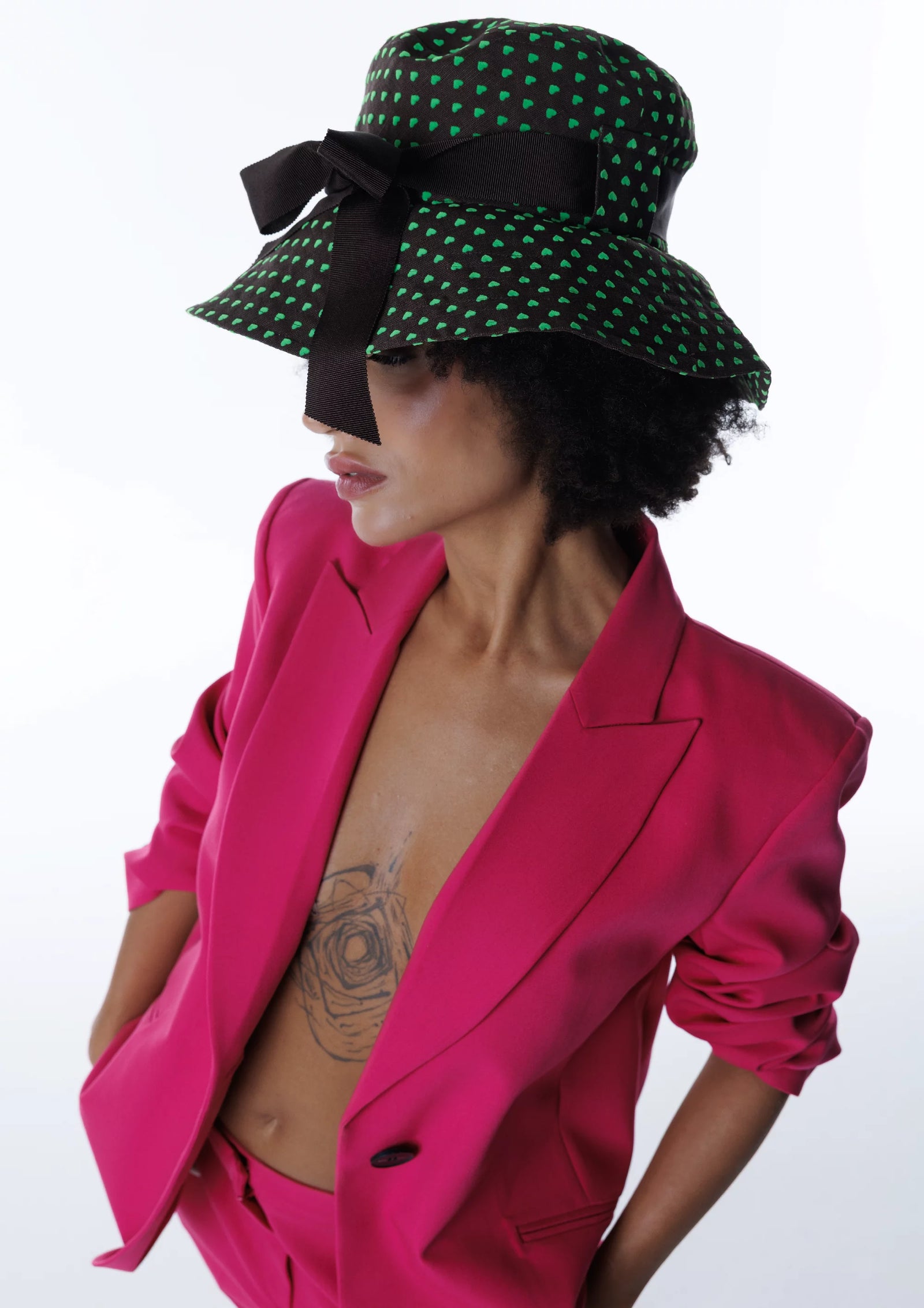 Yeşil noktalı şapka ve pembe takım kombinasyonuyla cesur moda pozu. Pentome Studio’da çekilmiştir.
Bold fashion pose with a green dotted hat and pink suit combination. Photographed at Pentome Studio.
